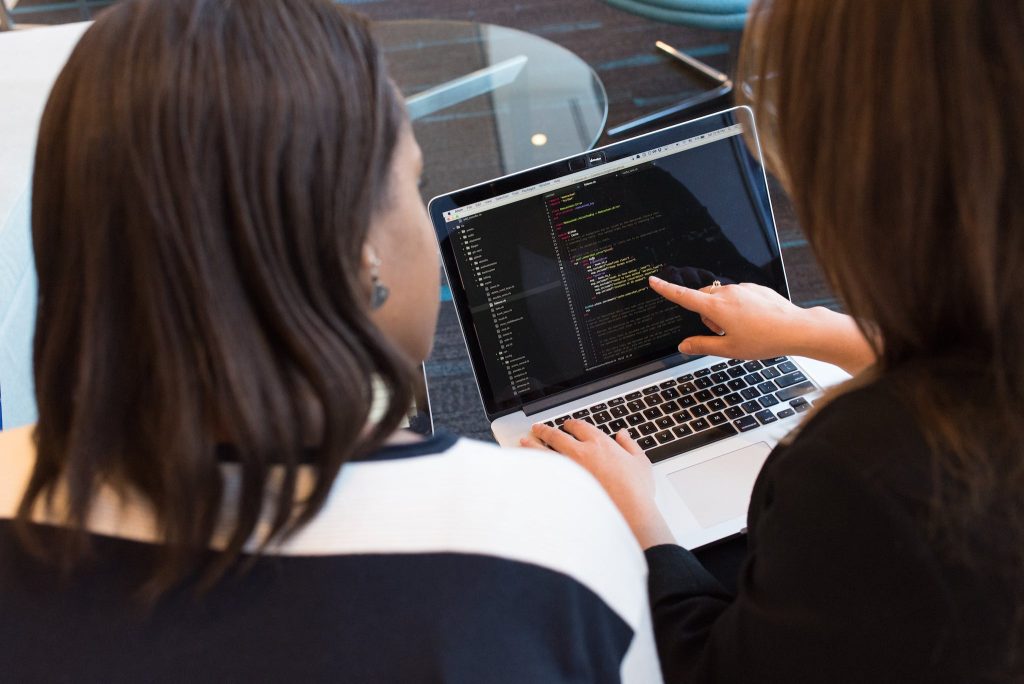 Veddys, Two Women Looking at the Code at Laptop